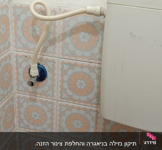 אסלה עם צינור מים מחובר לקיר
